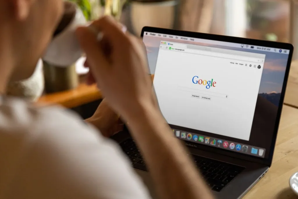 An accommodation owner analyzes Google search results on a laptop.