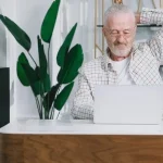 Właściciel pensjonatu analizujący statystyki rezerwacji na laptopie.