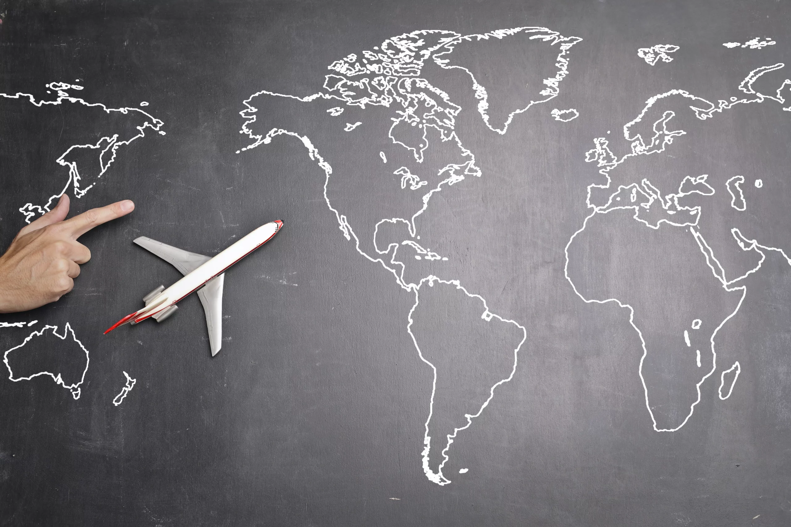 A travel symbol - an airplane against a world map, representing the global market for accommodation rentals.