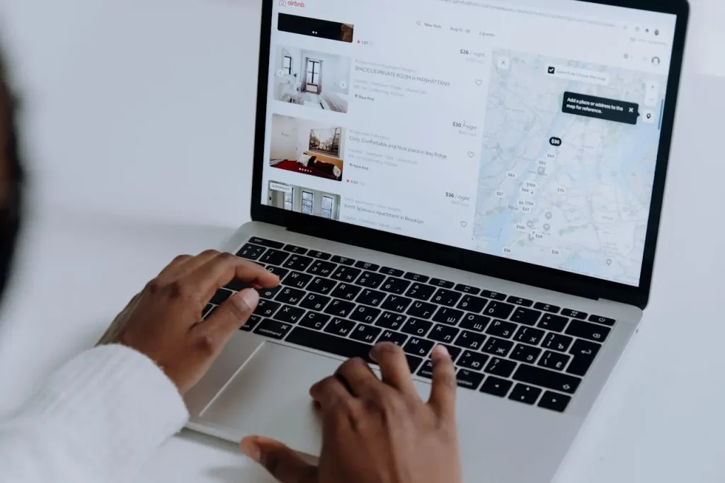 A property owner checking availability and listings on Airbnb using a laptop