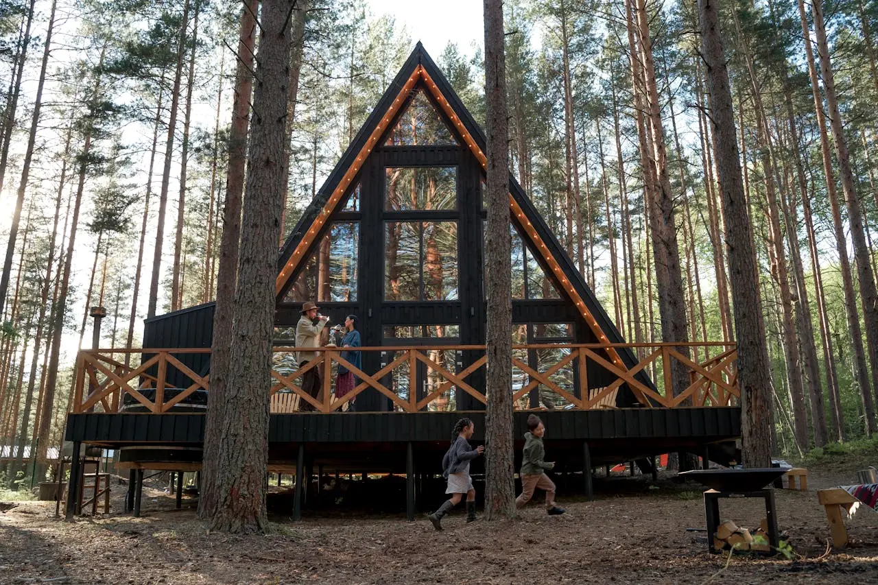 Widok na przytulny domek letniskowy w lesie, idealny na rodzinny wypoczynek