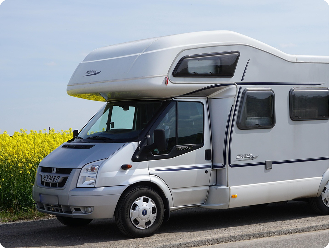 Srebrny kamper na trasie - przykład pojazdu obsługiwanego przez program do wynajmu kamperów.