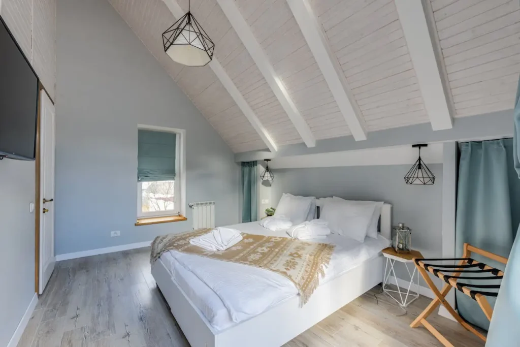 Sypialnia w apartamencie na wynajem krótkoterminowy – zaścielone łóżko, naturalne światło, standard Superhost Airbnb.
